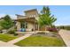 Contemporary-style home with a covered porch and blue chairs, surrounded by lush landscaping and modern design elements at 9636 Bennett Peak St, Littleton, CO 80125