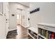 Bright hallway with hardwood flooring, a bench, and access to multiple rooms, showcasing the home's layout at 9636 Bennett Peak St, Littleton, CO 80125
