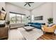 Bright living room featuring a large window, a modern sofa, hardwood floors, and stylish decor at 9636 Bennett Peak St, Littleton, CO 80125