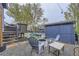 Backyard featuring a gravel seating area, blue shed, and chairs around a fire pit at 5550 E 130Th Dr, Thornton, CO 80241