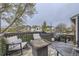 Cozy outdoor deck area with comfortable seating, decorative greenery, and a grill for outdoor cooking at 5550 E 130Th Dr, Thornton, CO 80241