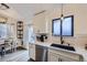 Modern kitchen with black sink, black window frame, white cabinets and quartz countertops at 5550 E 130Th Dr, Thornton, CO 80241