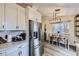 Bright kitchen with stainless steel refrigerator, white cabinets, and wood-look floors at 5550 E 130Th Dr, Thornton, CO 80241