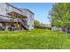 Spacious backyard with lush green grass, large deck, patio, and storage shed at 5660 E Burlington Dr, Castle Rock, CO 80104