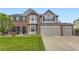 Beautiful two-story home with brick and gray siding, a well-manicured lawn, and a three-car garage at 5660 E Burlington Dr, Castle Rock, CO 80104
