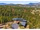 Stunning aerial view of the home nestled among lush trees and mountain views at 3395 Timbergate Trl, Evergreen, CO 80439