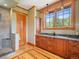 Bright bathroom featuring dual sink vanity, walk-in shower, and natural wood trim around a large window at 3395 Timbergate Trl, Evergreen, CO 80439