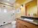 Stylist bathroom featuring glass shower, wood cabinets, granite countertops, and modern lighting at 3395 Timbergate Trl, Evergreen, CO 80439