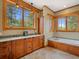 Luxurious bathroom featuring a soaking tub, vanity with double sinks, and large windows at 3395 Timbergate Trl, Evergreen, CO 80439