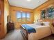 Cozy bedroom with natural light, a sleigh bed, wood trim, and a mountain view at 3395 Timbergate Trl, Evergreen, CO 80439