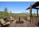 Relaxing outdoor deck with comfortable seating, an umbrella, and picturesque views of the surrounding landscape at 3395 Timbergate Trl, Evergreen, CO 80439