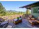 Outdoor deck features mountain views, wood flooring, and cozy seating, perfect for relaxation and entertaining at 3395 Timbergate Trl, Evergreen, CO 80439