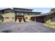 Exterior showcasing garage and basketball court on driveway, enhanced by natural stone accents and lush landscaping at 3395 Timbergate Trl, Evergreen, CO 80439