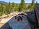 Outdoor fire pit area with circular stone patio and stump seating perfect for entertaining and enjoying mountain views at 3395 Timbergate Trl, Evergreen, CO 80439