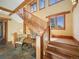 Grand foyer with wooden staircase and large windows offering natural light at 3395 Timbergate Trl, Evergreen, CO 80439
