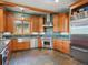 Well-equipped kitchen featuring stone tile flooring, stainless appliances, and custom cabinetry at 3395 Timbergate Trl, Evergreen, CO 80439