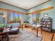 Bright office space featuring large windows, a wooden desk, and a cozy reading area at 3395 Timbergate Trl, Evergreen, CO 80439
