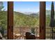 Breathtaking mountain views from the deck, framed by an open sliding glass door at 3395 Timbergate Trl, Evergreen, CO 80439