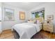 Bright bedroom with hardwood floors, two windows, and stylish bedside tables and lamps at 2100 N Franklin St # 5, Denver, CO 80205