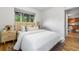 Bright bedroom featuring hardwood floors, a large window, and neutral decor with a view to the hallway at 2100 N Franklin St # 5, Denver, CO 80205