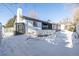 Backyard featuring a covered deck, grill, shed, and privacy fence in the snow at 2538 S Dover Way, Lakewood, CO 80227