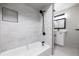 Bathroom featuring a tub with marble tile surround, black fixtures, and a modern vanity at 2538 S Dover Way, Lakewood, CO 80227