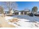 Front view of a ranch style home with a two car garage, and snowy yard at 2538 S Dover Way, Lakewood, CO 80227