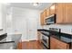 Modern kitchen features stainless steel appliances, wood cabinetry, and granite countertops at 4100 Albion St # 614, Denver, CO 80216