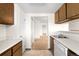 Kitchen features white appliances, wooden cabinets, and an open view to the hallway at 3041 S Ursula Cir # 302, Aurora, CO 80014