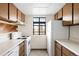 Efficient kitchen with white appliances, wooden cabinetry, and a bright window at 3041 S Ursula Cir # 302, Aurora, CO 80014