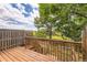 Outdoor deck space with wood railing offers beautiful views of the community green space and trees at 8243 S Fillmore Cir, Centennial, CO 80122