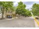 View of townhomes in a row, featuring attached garages and mature trees lining the street at 8243 S Fillmore Cir, Centennial, CO 80122