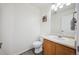 Well-lit half bathroom featuring a toilet, and wood vanity with solid surface countertop at 14828 E 118Th Pl, Commerce City, CO 80603