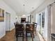 Dining room with wood floors, large window, and a full dining table connected to an open kitchen concept at 14828 E 118Th Pl, Commerce City, CO 80603