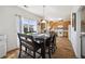 Dining room with wood floors, large window, and a full dining table connected to an open kitchen concept at 14828 E 118Th Pl, Commerce City, CO 80603