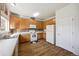 Bright kitchen with wooden cabinets, white appliances, and multicolored tile backsplash at 14828 E 118Th Pl, Commerce City, CO 80603