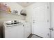 Well-lit laundry room featuring a washer, dryer, storage shelf and access door at 14828 E 118Th Pl, Commerce City, CO 80603