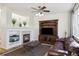 Inviting living room with fireplace, mounted tv, aquarium, hardwood floors, and a comfortable leather sofa at 14828 E 118Th Pl, Commerce City, CO 80603