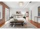 Spacious bedroom with exposed brick accent wall, hardwood floors, rug, and contemporary lighting fixture at 624 E 18Th Ave # 4, Denver, CO 80203