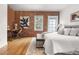 Bedroom features exposed brick accent wall, home office setup, hardwood floors, rug, and natural light at 624 E 18Th Ave # 4, Denver, CO 80203