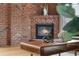 A close-up of a fireplace features a brick hearth and wooden coffee table at 624 E 18Th Ave # 4, Denver, CO 80203