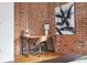 Cozy home office nook with exposed brick wall, hardwood floors, and desk with chair at 624 E 18Th Ave # 4, Denver, CO 80203