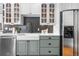 Kitchen with white upper cabinets, green lower cabinets, a stainless steel refrigerator and a black tile backsplash at 624 E 18Th Ave # 4, Denver, CO 80203