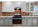 Modern kitchen features granite countertops, exposed brick and white cabinets at 624 E 18Th Ave # 4, Denver, CO 80203