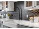 Updated kitchen features white countertops, a farmhouse sink, and a modern black hexagon tile backsplash at 624 E 18Th Ave # 4, Denver, CO 80203
