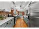 Open concept kitchen with stainless steel appliances, quartz counters, brick accents and hardwood floors at 624 E 18Th Ave # 4, Denver, CO 80203