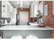 Bright kitchen area featuring an island with white countertops, brick accent wall, and stainless steel appliances at 624 E 18Th Ave # 4, Denver, CO 80203
