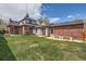A spacious backyard offering a generous lawn area and a quaint pergola that's perfect for outdoor activities and relaxation at 1418 Glencoe St, Denver, CO 80220