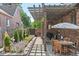 Inviting outdoor patio with a pergola, brickwork, and a table with chairs at 1418 Glencoe St, Denver, CO 80220