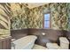 Bathroom showcasing floral wallpaper, clawfoot tub, and wainscoting, offering a vintage charm at 1418 Glencoe St, Denver, CO 80220